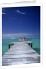 couple Sitting On A Pier In An Ocean Lagoon by Anonymous