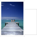 couple Sitting On A Pier In An Ocean Lagoon by Anonymous