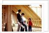 1980s family of four inspecting new home under construction by Anonymous