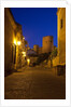 Streets of Banos de la Encina at night with the Moorish castle, named Burgalimar Castle, in the back by Anonymous