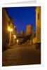 Streets of Banos de la Encina at night with the Moorish castle, named Burgalimar Castle, in the back by Anonymous