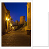 Streets of Banos de la Encina at night with the Moorish castle, named Burgalimar Castle, in the back by Anonymous