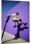 Boy Wearing Roller Blades Jumping Against Wall by Anonymous