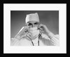 1960s male doctor wearing surgical mask and operating room scrubs by Anonymous