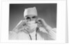 1960s male doctor wearing surgical mask and operating room scrubs by Anonymous