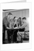 1950s group of businessmen looking at a blueprint on a table by Anonymous