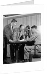 1950s group of businessmen looking at a blueprint on a table by Anonymous