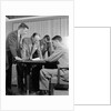 1950s group of businessmen looking at a blueprint on a table by Anonymous