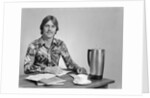1970s smiling young man working on a budget by Anonymous