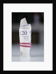 A roll of twenty pound notes on a table by Anonymous