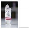 A roll of twenty pound notes on a table by Anonymous