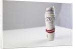 A roll of twenty pound notes on a table by Anonymous