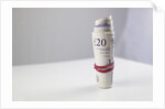 A roll of twenty pound notes on a table by Anonymous