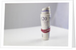 A roll of twenty pound notes on a table by Anonymous