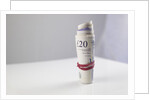 A roll of twenty pound notes on a table by Anonymous