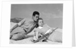 1930s couple lying on a beach by Anonymous