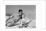 1930s couple lying on a beach by Anonymous