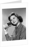 1960s smiling teenage girl listening to portable radio by Anonymous