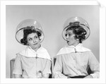 1960s two women sitting under hairdryers gossiping by Anonymous