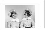1960s two women sitting under hairdryers gossiping by Anonymous