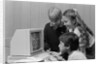 1980s boys and girl playing games on a computer by Anonymous