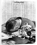1930s man with head on his desk holding stock ticker tape by Anonymous