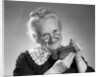 1950s portrait of senior woman putting change into a purse by Anonymous