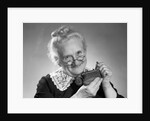 1950s portrait of senior woman putting change into a purse by Anonymous