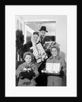 1960s family standing in doorway wearing winter coats and holding Christmas presents by Anonymous