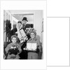 1960s family standing in doorway wearing winter coats and holding Christmas presents by Anonymous