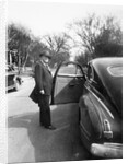 Mature man open his car door, ca. 1940. by Anonymous