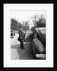 Mature man open his car door, ca. 1940. by Anonymous