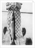 Woman holds on large Northern Pike on a lake pier, ca. 1950. by Anonymous