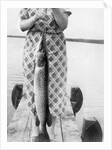 Woman holds on large Northern Pike on a lake pier, ca. 1950. by Anonymous