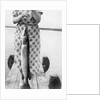 Woman holds on large Northern Pike on a lake pier, ca. 1950. by Anonymous