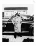 Mature man stands by his car, ca. 1942. by Anonymous