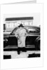 Mature man stands by his car, ca. 1942. by Anonymous
