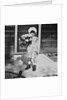 Young girl with a bouquet of flowers on her doorstep, ca. 1928. by Anonymous