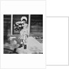 Young girl with a bouquet of flowers on her doorstep, ca. 1928. by Anonymous