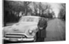 Senior man with his automobile on an Illinois street, ca. 1950. by Anonymous