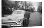 Senior man with his automobile on an Illinois street, ca. 1950. by Anonymous