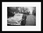 Senior man with his automobile on an Illinois street, ca. 1950. by Anonymous