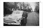 Senior man with his automobile on an Illinois street, ca. 1950. by Anonymous