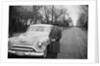 Senior man with his automobile on an Illinois street, ca. 1950. by Anonymous