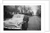 Senior man with his automobile on an Illinois street, ca. 1950. by Anonymous