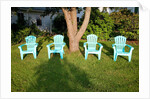 Turquois lawn chairs and green grass at sunset by Anonymous