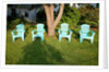 Turquois lawn chairs and green grass at sunset by Anonymous