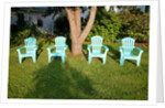 Turquois lawn chairs and green grass at sunset by Anonymous
