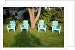Turquois lawn chairs and green grass at sunset by Anonymous