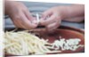 Woman selecting and separating green beans from pods by Anonymous